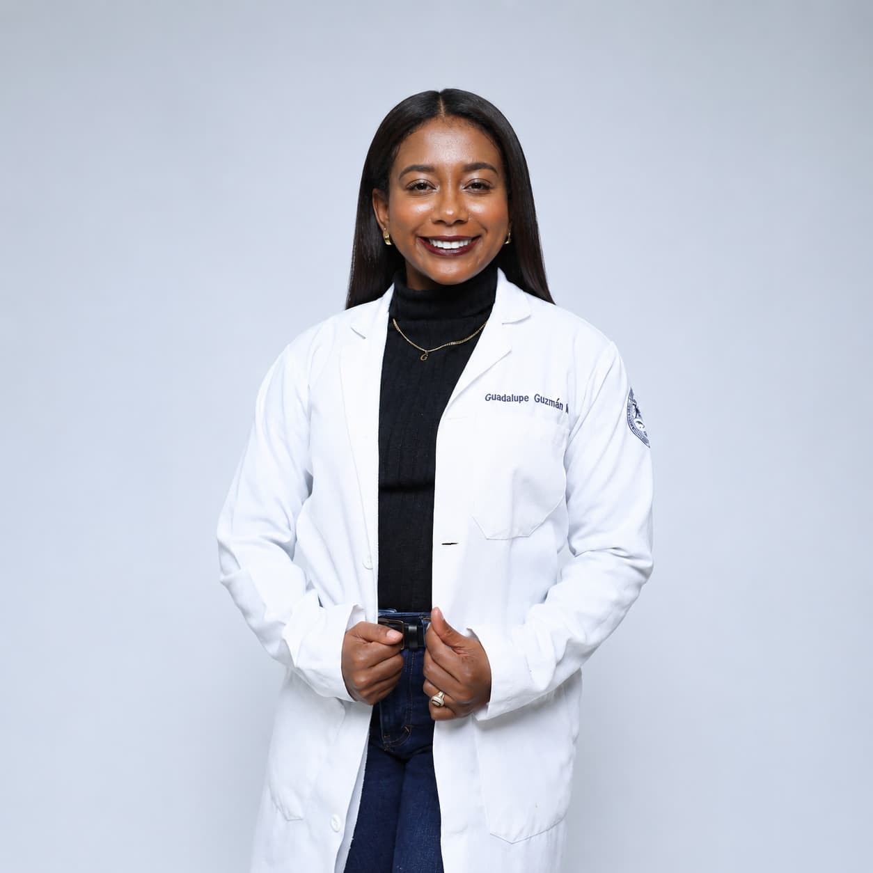 Guadalupe Guzmán, médico nutrióloga clínica, con bata blanca bordada con su nombre completo